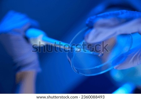 Man in uniform manipulates biomaterial in a modern laboratory