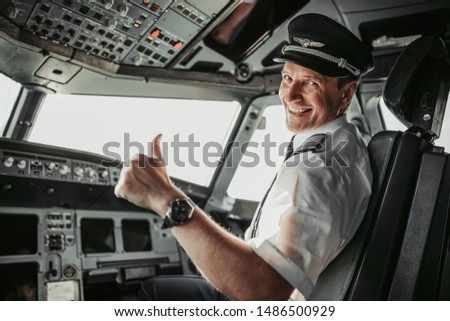 Man in uniform showing ok gesture stock photo. Airways concept