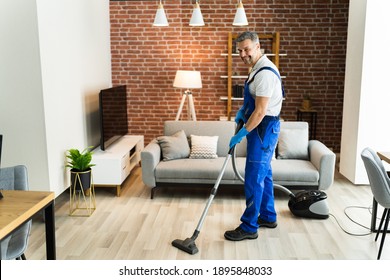 Man In Uniform Vacuuming House Floor. Cleaning Home