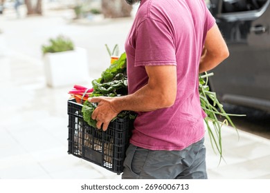 Man unloading box of assorted vegetables from van - Powered by Shutterstock - Get 15% off with code: PIKWIZARD15