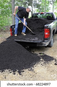 Man Unloading Compost From Pickup Truck