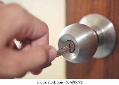 the man is unlocking the door by key
