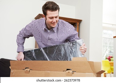 Man Unpacking New Television At Home