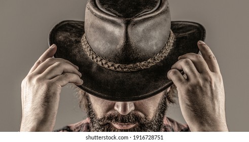 Man unshaven cowboys. American cowboy. Leather Cowboy Hat. Portrait of young man wearing cowboy hat. Cowboys in hat. Handsome bearded macho.