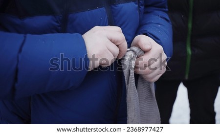 Man untying rope. Clip. Close-up of man holding rope with knot for towing car. Man unties rope to tow car in winter 商業照片 © 