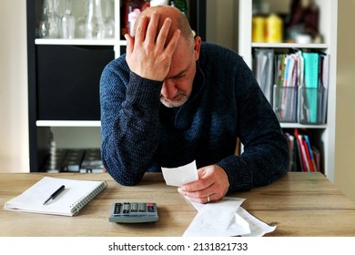 Man upset headache depressed from family cost got higher doing accounting holding receipts from supermarket with calculator by rising grocery prices and surging cost as an inflation financial crisis. - Shutterstock ID 2131821733