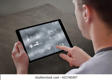 Man use application for smart home control on tablet. Interior of living room in the background. - Powered by Shutterstock