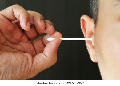 Man use cotton bud swab to clean to clear ear wax Harmful for ear