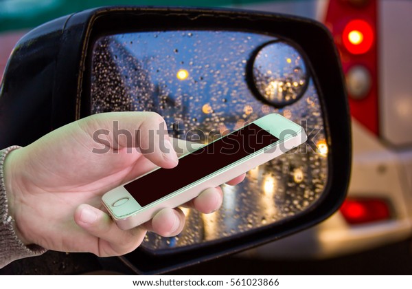 Man use mobile phone, abstract of cars in the\
rain as background.