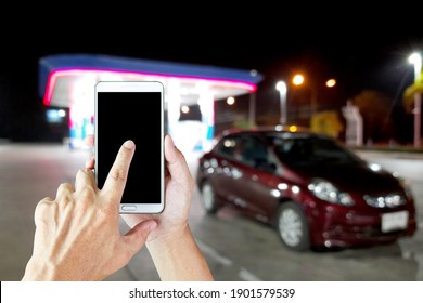 Man Use Mobile Phone, Blur Image Of Gas Station At Night As Background.