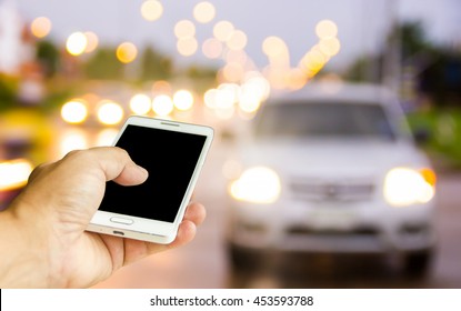 Man Use Mobile Phone, Blur Image Of The Car Was Parked On The Street As Background.