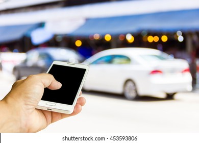 Man Use Mobile Phone, Blur Image Of The Car Was Parked On The Street As Background.