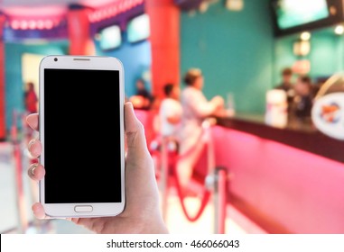 Man Use Mobile Phone, Blur Image Of Kid Buying Movie Ticket As Background.