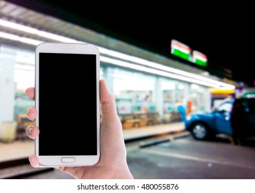 Man Use Mobile Phone, Blur Image Of Outside The Convenience Store As Background.