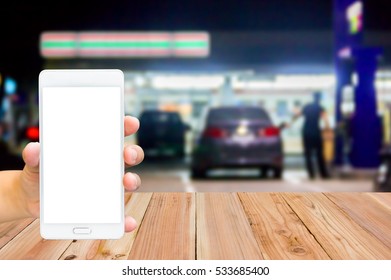 Man Use Mobile Phone , Blur Image Of In Front Of The Store Inside Gas Station As Background.