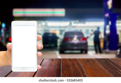 Man Use Mobile Phone , Blur Image Of In Front Of The Store Inside Gas Station As Background.