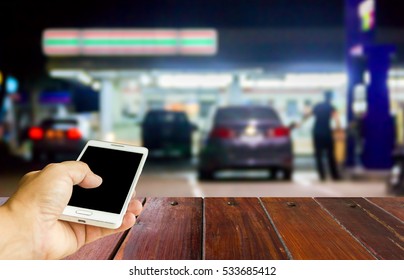 Man Use Mobile Phone , Blur Image Of In Front Of The Store Inside Gas Station As Background.