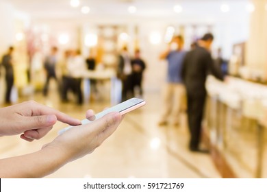 Man use mobile phone ,blur image of a lot of people talk in front of the meeting room.(On vintage tone) - Powered by Shutterstock