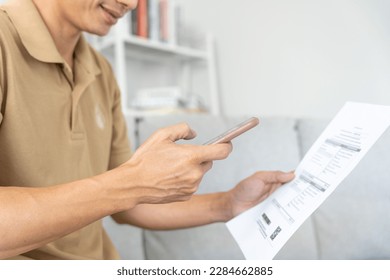 man use phone to scan barcode or QR codes to pay credit card bill after receiving document invoice online. payment, receive, paying electricity, digital payments without money, technology, scanning