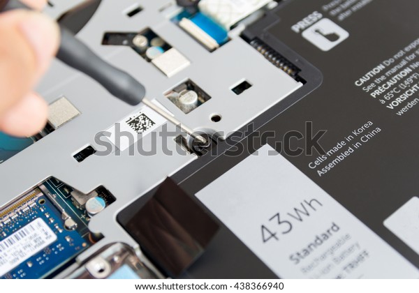 man use a screwdriver to remove the battery for\
repair baterry laptop
