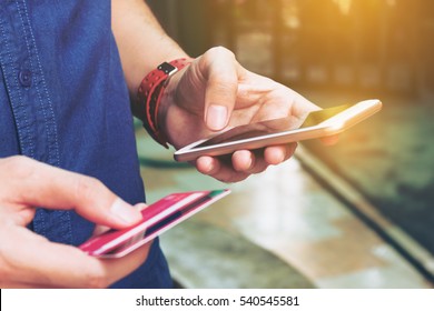 Man Use Smart Phone And Holding Credit Card With Shopping Online. Online Payment Concept.