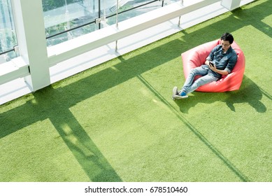 Man Use Smartphone On Bean Bag In Afternoon, Freelance Conceptual Lifestyle, Internet In Everyday Life