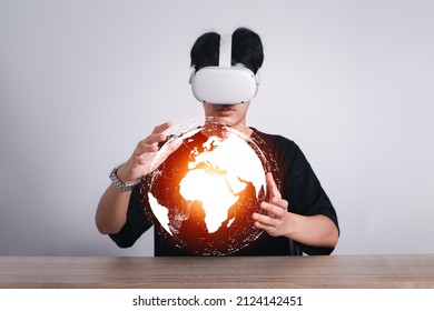 Man Use Vr Glasses And Looks At World Map Metaverse Technology, Studio Shot.Virtual Gadgets For Entertainment, Work, Free Time And Study. Game Cyber Virtual Reality Technology Concept.