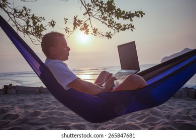 Man Uses Laptop Remotely At The Beach