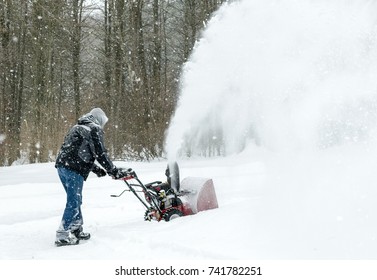 Man  Uses Snow Blower To Clear Snow From Driveway 