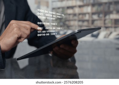 A man uses a tablet showing binary code in a sleek office space, emphasizing the fusion of technology and data processing in modern business environments.