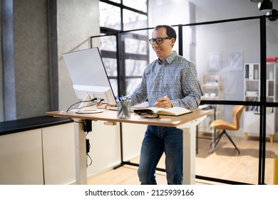 Man Using Adjustable Height Standing Desk In Office For Good Posture