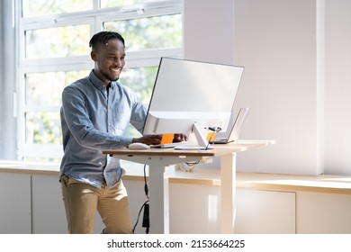 Man Using Adjustable Height Standing Desk In Office For Good Posture