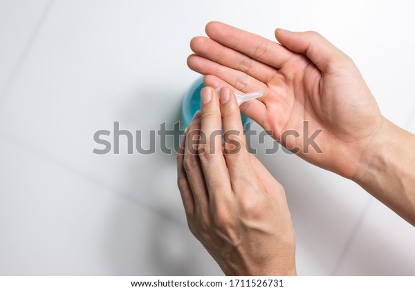 Man using alcohol gel, hand sanitizer gel pump\
dispenser for protection coronavirus disease (covid-19) and germ \
(select focus)
