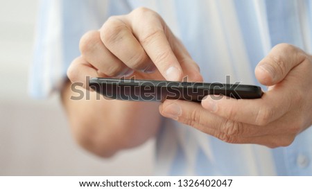 A man using apps on a mobile touchscreen smartphone. Concept of modern technology, shopping online and smart phones