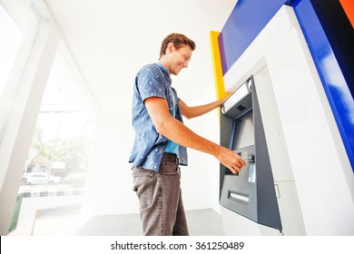 Man Using Atm To Withdraw Cash