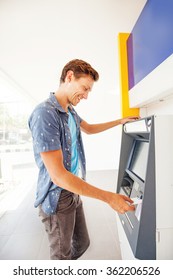 Man Using Atm To Withdraw Cash