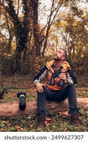 Man using binoculars and camera for bird and animal watching in nature.