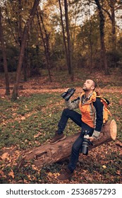 Man using binoculars and camera for bird and animal watching in nature.