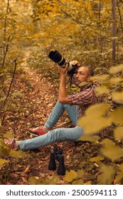 Man using binoculars and camera for birdwatching and other observing animals in nature.