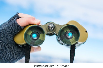 Man Using Binoculars On A Snow Covered Mountain