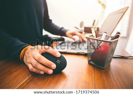 The man using black vertical optical computer mouse with ergonomic design and leave normal computer mouse in the basket.
