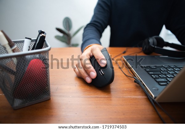 The\
man using black vertical optical computer mouse with ergonomic\
design and leave normal computer mouse in the\
basket.