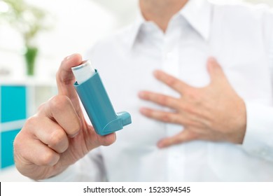 Man Using Blue Asthma Inhaler Medication With Breathing Difficulties