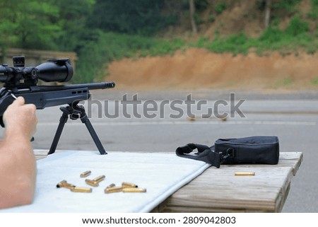 Man using bolt action to eject shell at the rifle range