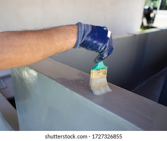 
Man Using A Brush To Paint A Swimming Pool