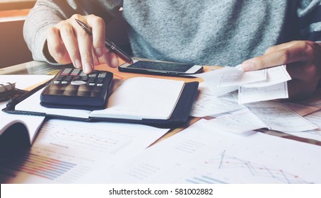Man using calculator and calculate bills in home office.