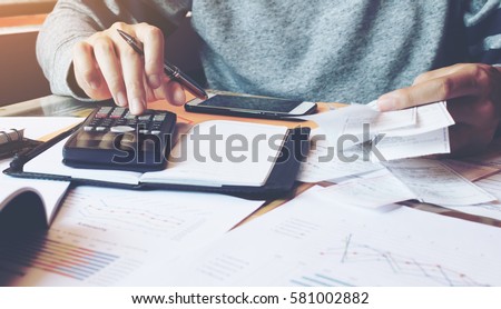 Man using calculator and calculate bills in home office.
