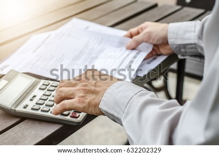 Man using calculator and thinking about cost  with paying bills