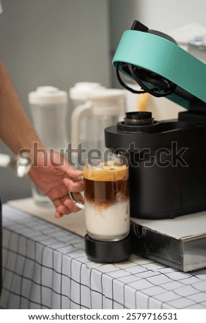 Man using capsule coffee machine with espresso cup. Nespresso is worldwide leader company with coffe machines and capsules.
