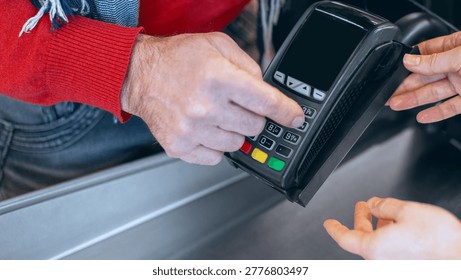 Man Using Card Reader to Pay at a Checkout Counter in a Store During Daytime